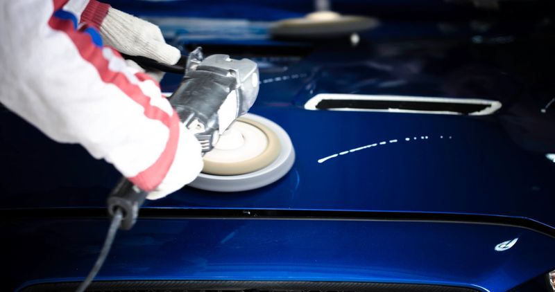 polishing the hood with wax of a japanese race car