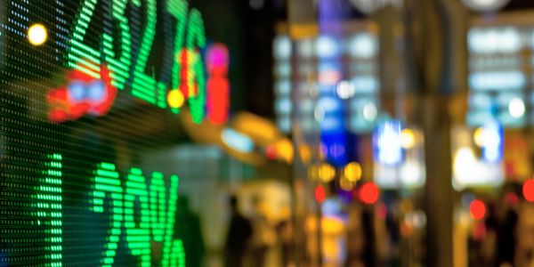 Digital stock market numbers displayed against city night lights.