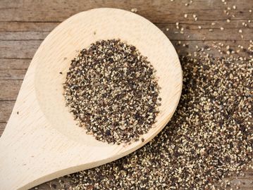 Crushed black pepper on a wooden spoon.