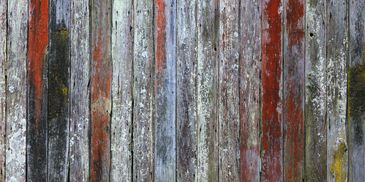 Weathered wooden planks with faded red paint and moss.