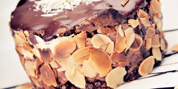 Close-up of a chocolate cake with almond slices and chocolate glaze.
