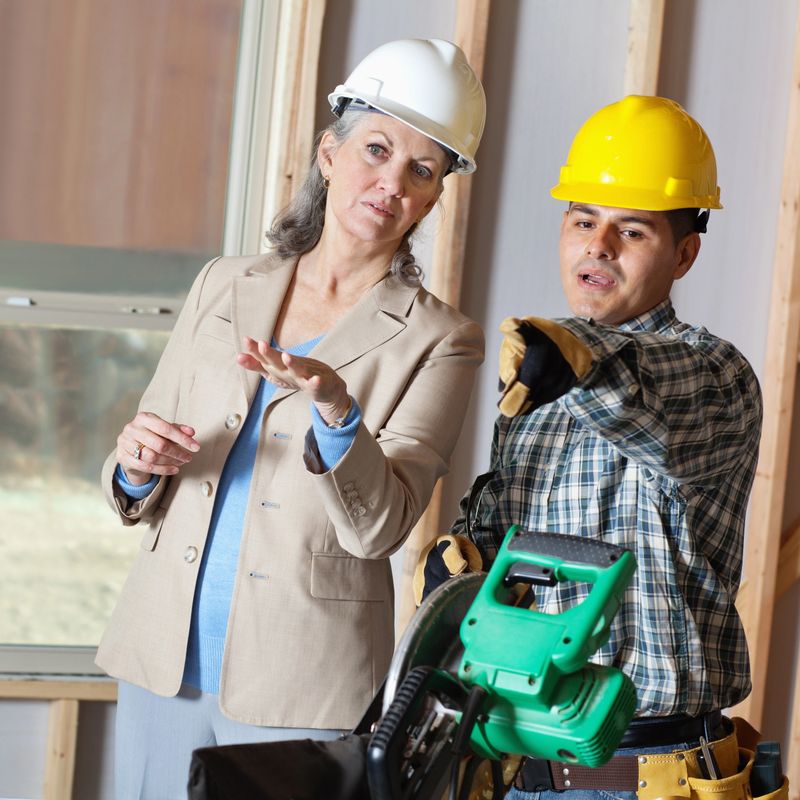 Construction foreman and manager talking about building plans.