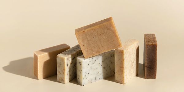 Various handmade soap bars arranged on a beige surface.