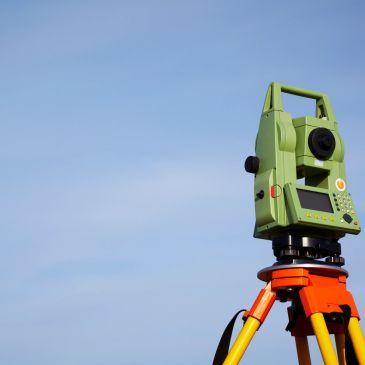 Surveying equipment set up against a clear sky.