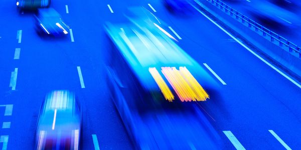 Blurred motion of vehicles on a busy multi-lane highway at night.