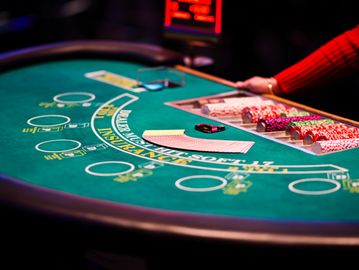 A blackjack table with cards, poker chips, and a dealer's hand.