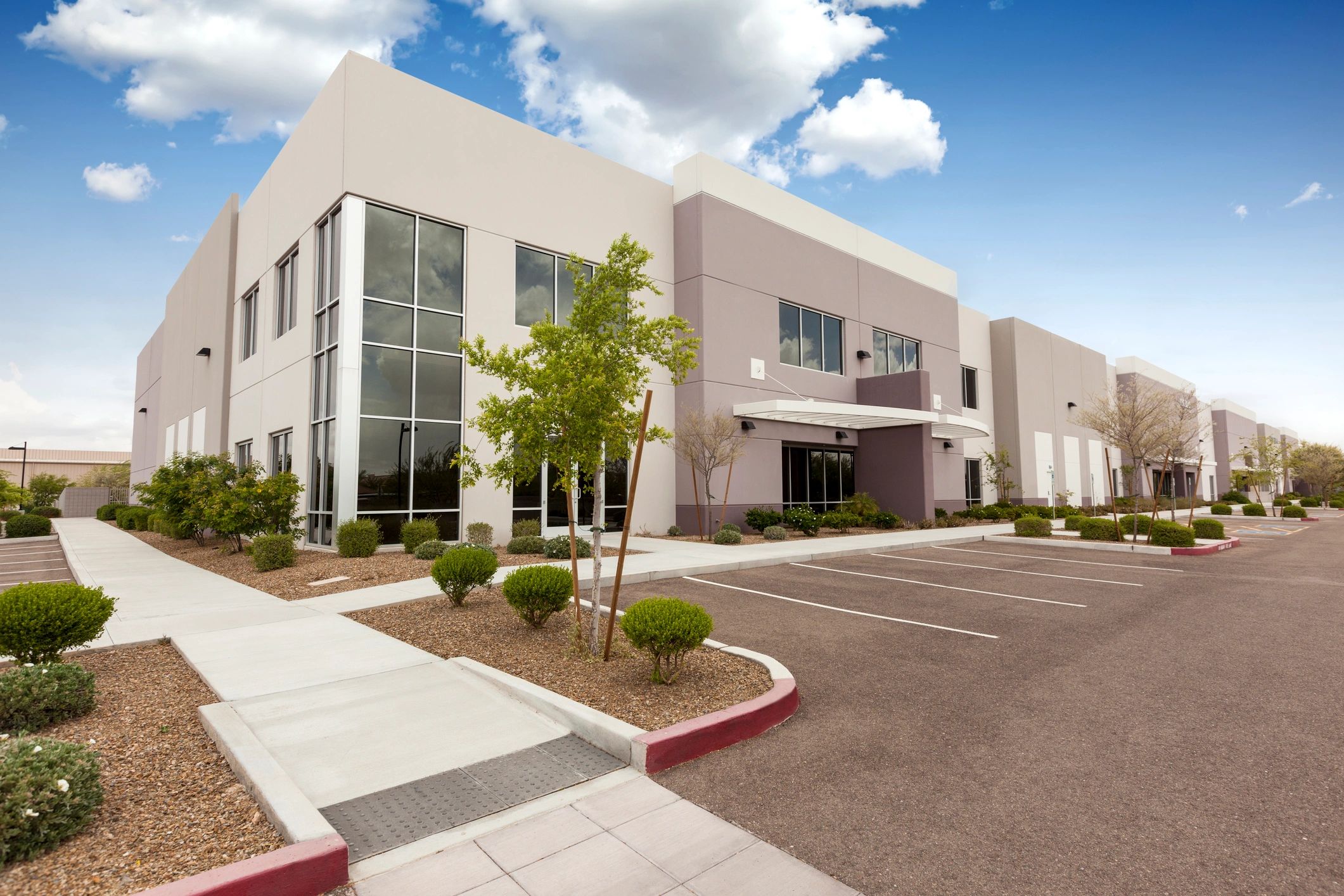 Modern commercial building with landscaping and parking lot.
