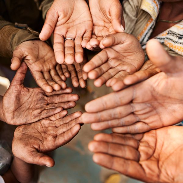 A circle of open hands reaching inward, symbolizing unity and support.