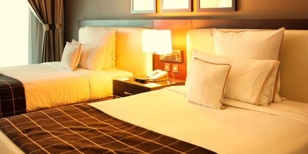 Cozy hotel room with two beds and warm lighting. Travel to new city. Adventures in new countries. Explore fun activities.