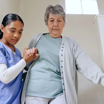 A nurse assisting an elderly woman down the stairs with care and support.