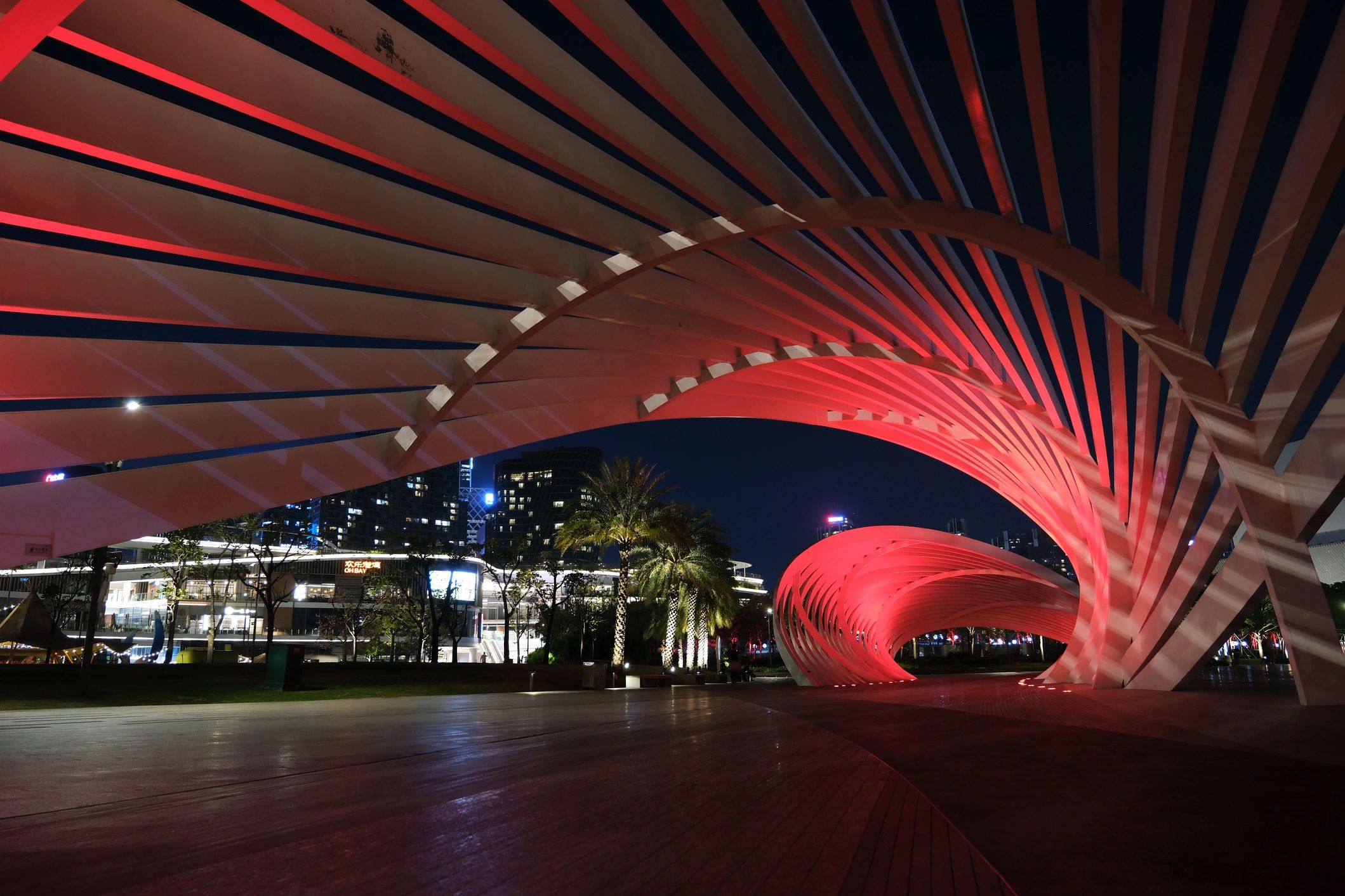 Red illuminated modern architectural structure at night.