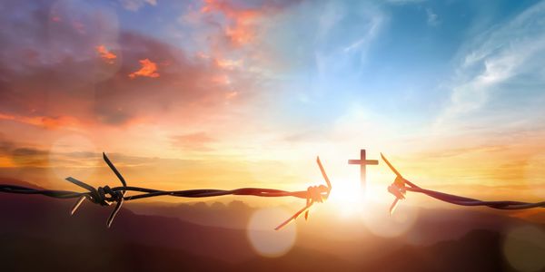 Barbed wire broken by a cross