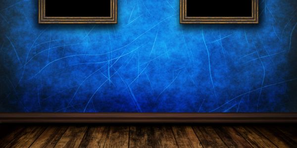 Empty room with blue textured walls and wooden floor.