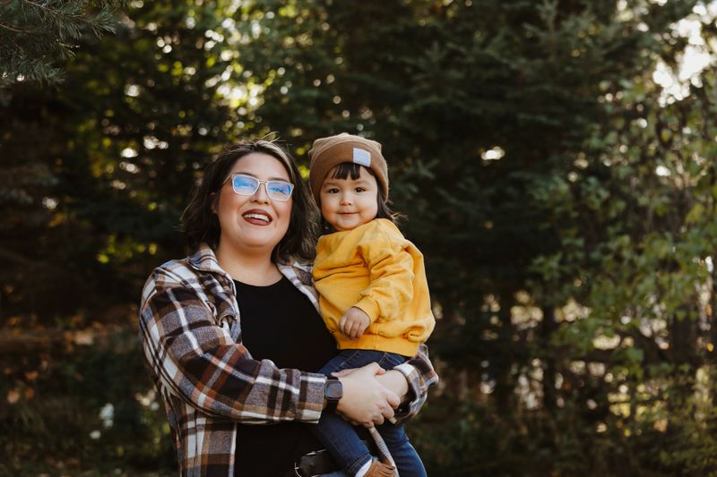 An image of a Native American two~year~old girl and her mother, outside.