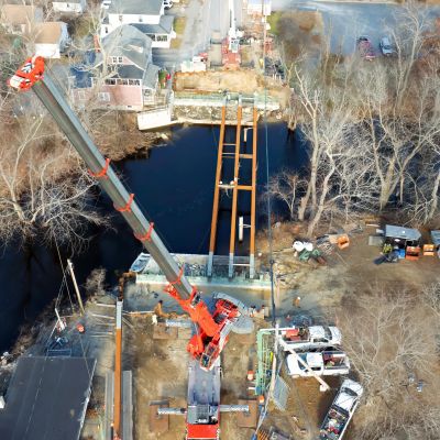 Aerial view of bridge construction over a river with a crane.