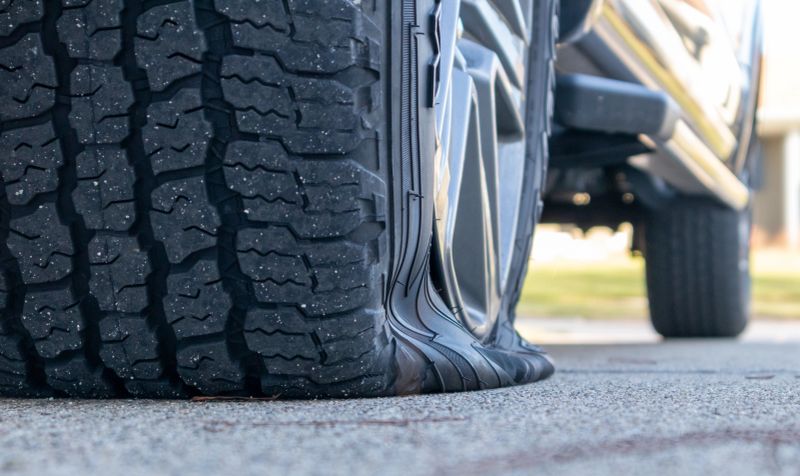 low angle view of a trucks flat tire on cement