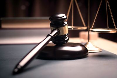 A judge's gavel and scales of justice on a desk.