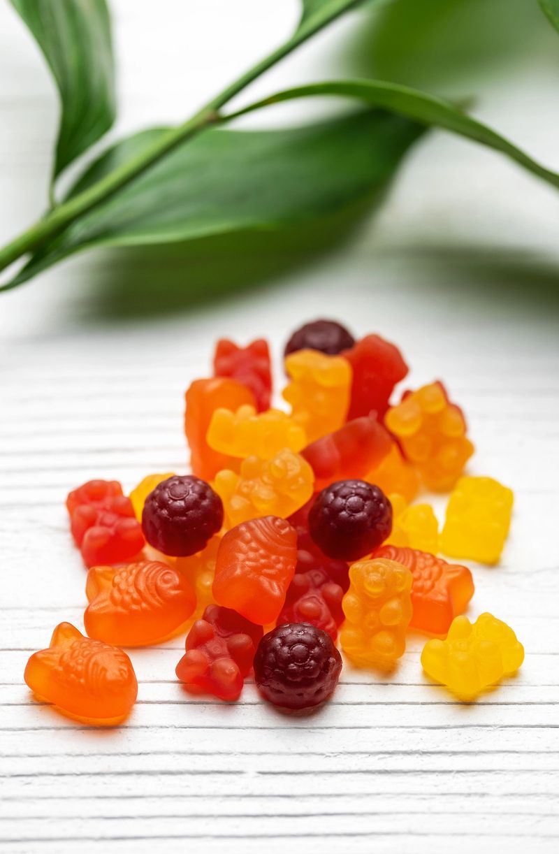Vitamins for children,   jelly gummy candy on white wooden background