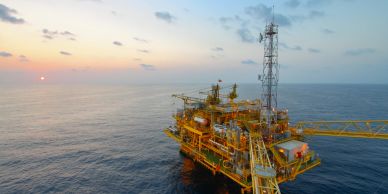 Oil platform in the ocean at sunset.