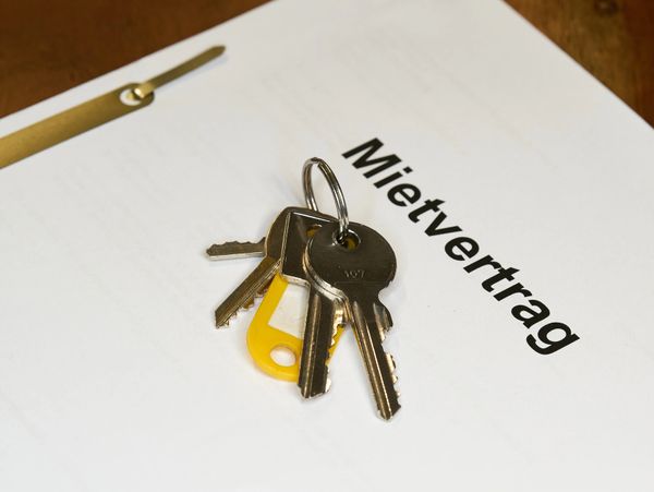 Keys resting on a German rental contract document titled 'Mietvertrag'.