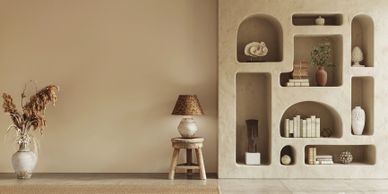 Minimalist beige room with rustic wooden ceiling and decorative niches.