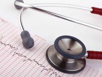 Stethoscope resting on an electrocardiogram (ECG) printout.