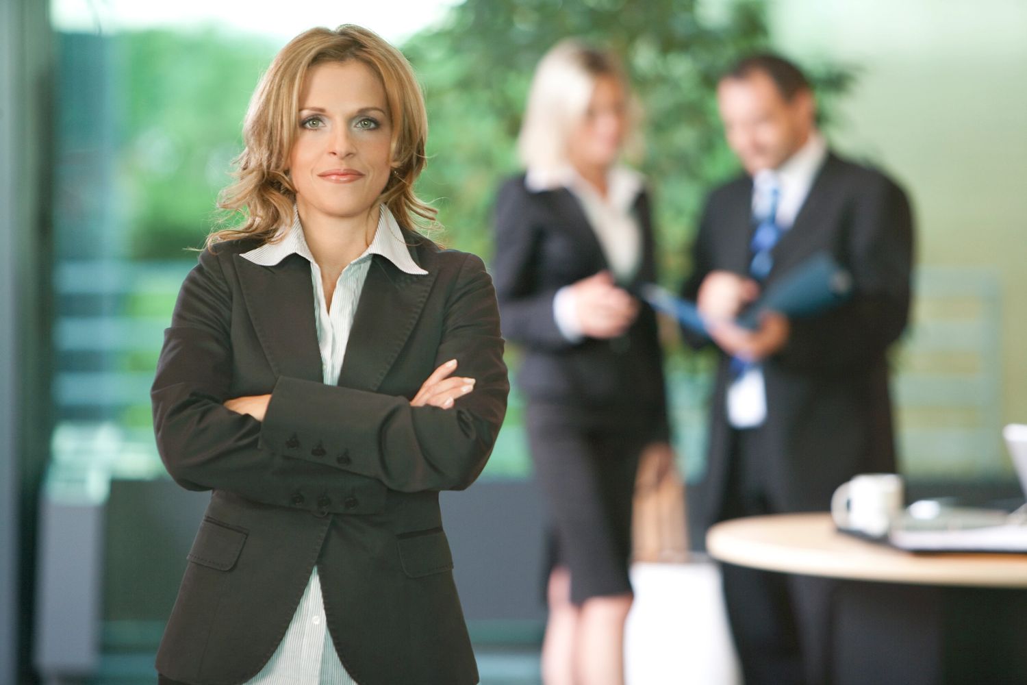 Stack of books next to pencils in a holder and a camera.