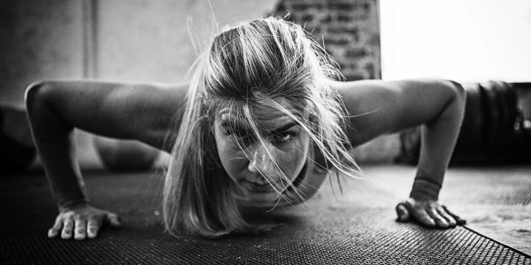 Focused woman doing push-ups indoors.