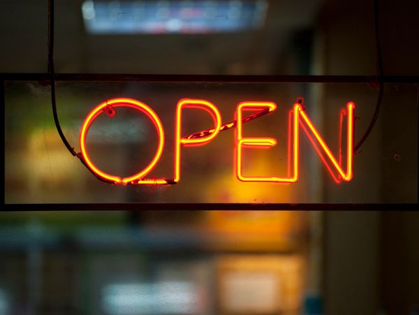 Bright orange neon sign displaying the word OPEN.
