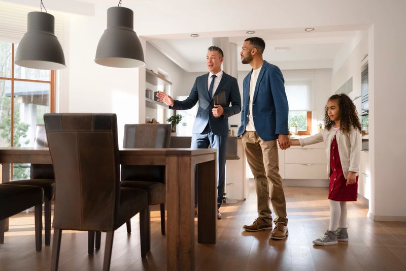 Male real estate agent showing modern luxury house to customer.