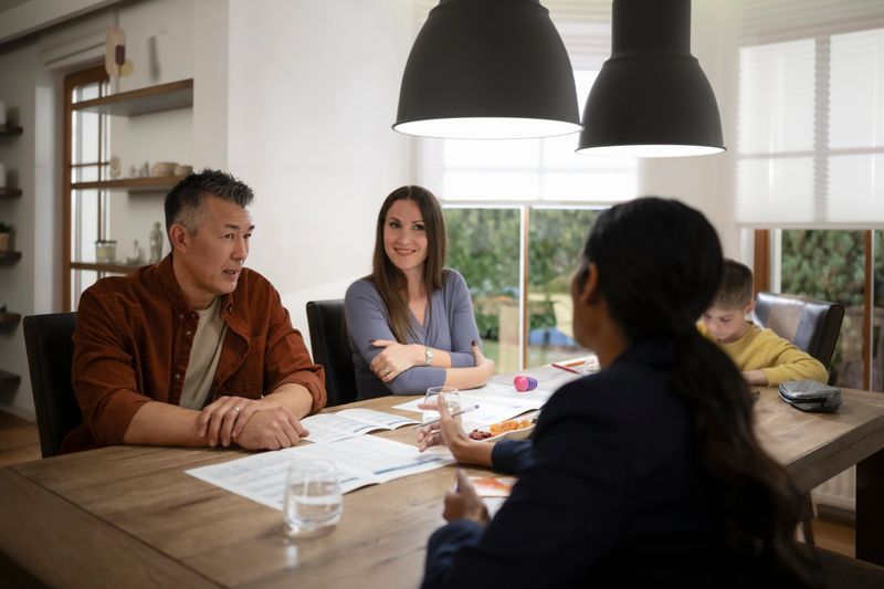 Customer discussion with financial advisor while sitting at dining table in new house.