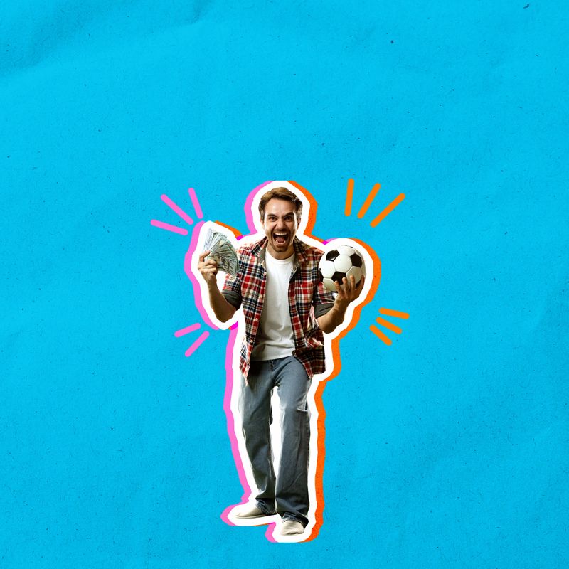 Young man in checkered shirt holding football ball and money, showing happiness and excitement over blue background. Concept of sport, betting, winning, game, finances, good luck, hobby