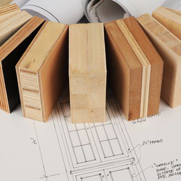 Muestras de diferentes tipos de madera sobre planos de diseño.