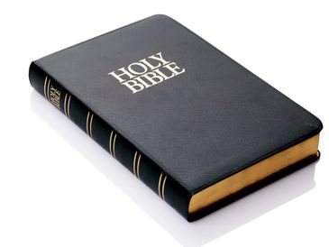 A black leather-bound Holy Bible with gold-edged pages.