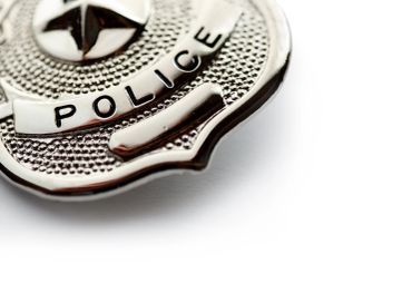 Close-up of a shiny police badge on a white background.