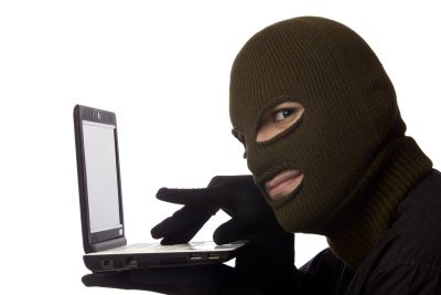 Person in ski mask using a laptop.
