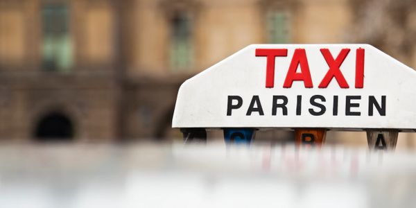 Close-up of a Parisian taxi sign with blurred background.