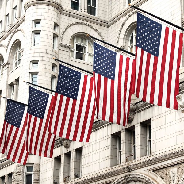 American flags on historic Washington DC building, major hub for federal and policy events.