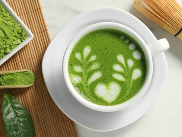 Cup of matcha green tea latte with latte art.