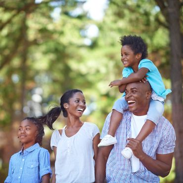 A joyful family enjoying a walk outdoors on a sunny day.