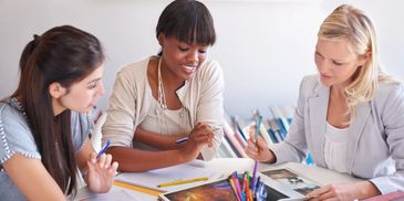 Three women studying and discussing together.