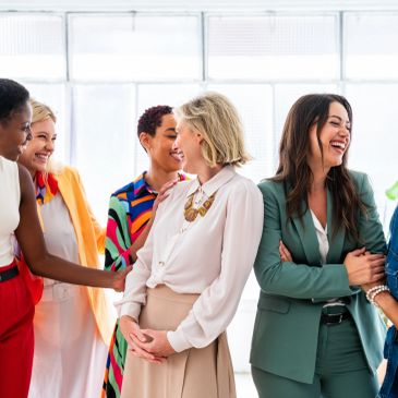 Group of diverse women smiling and chatting together.
