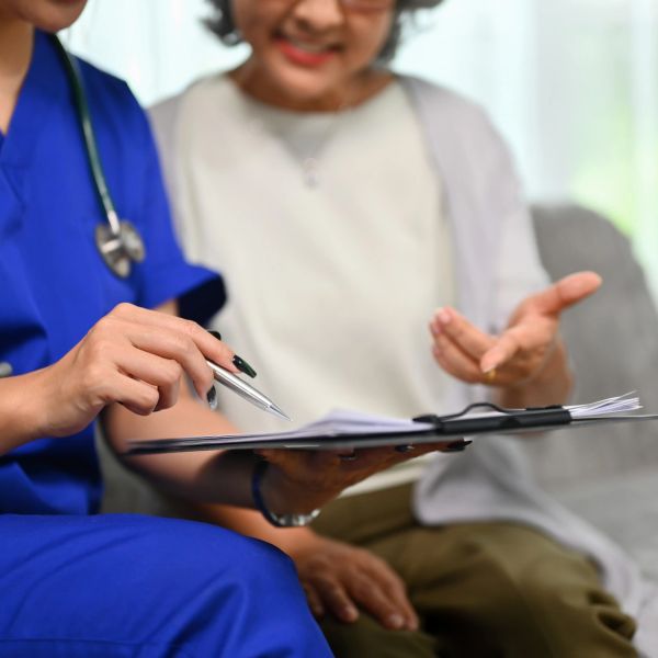 Nurse explaining documents to elderly patient.