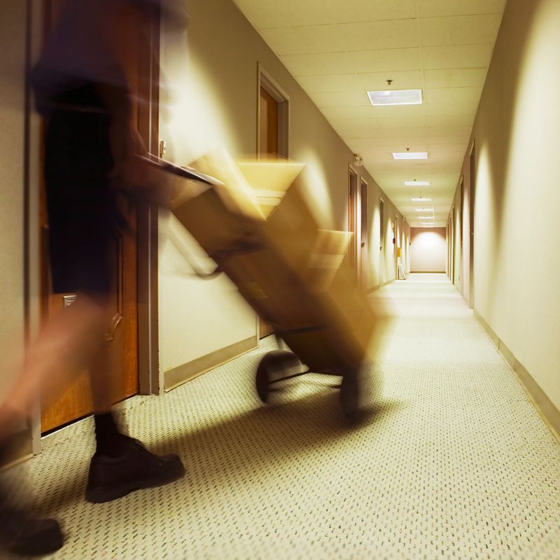 A courier making a delivery with boxes on a hand truck.  