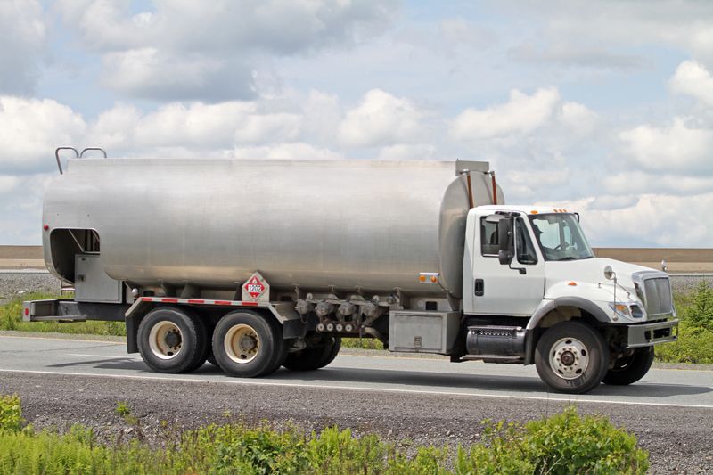 Side view of an oil delivery truck carrying furnace oil for home heating. Hazmat sign 1202 indicates heating oil is being carried.