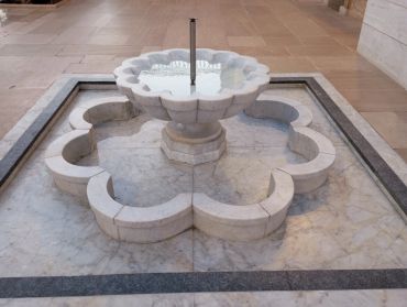 Marble flower-shaped fountain inside a building.