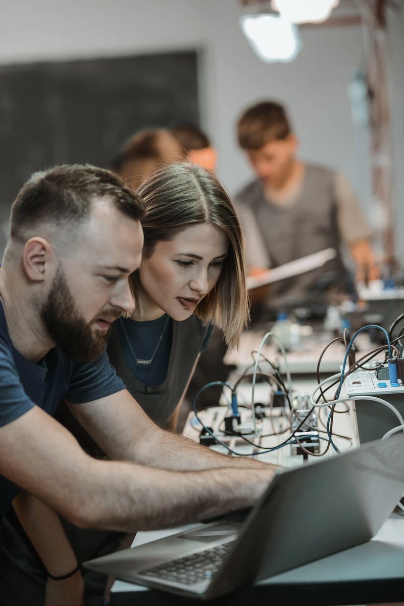 Focused Female Student Learning How To Connect PLC To Laptop