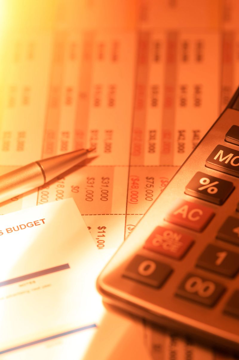Close-up of calculator and pen over financial reports.