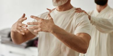 Two men practicing Tai Chi indoors.