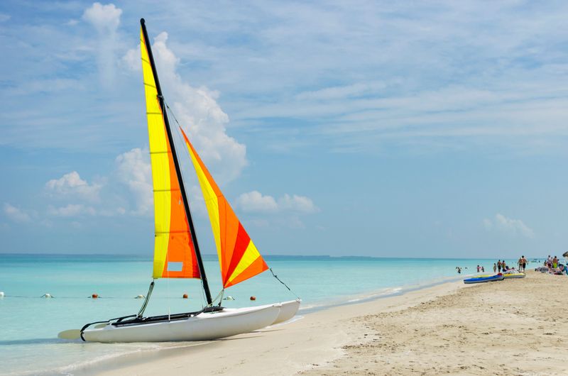 A brightly colored catamaran found on a golden beach in the Caribbean.